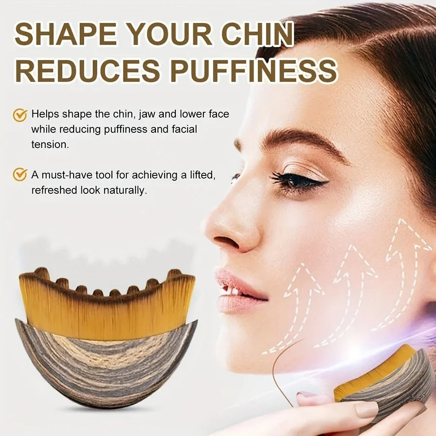 Crescent-shaped facial massage brush with wood-grain handle and soft golden-brown bristles for lymphatic contouring.