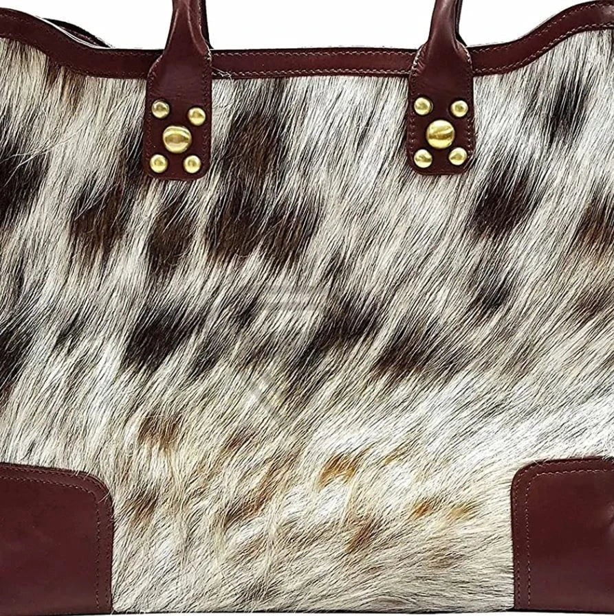 Premium cowhide leather tote bag, white and brown fur, designer handbag with dark leather trim and gold stud details.