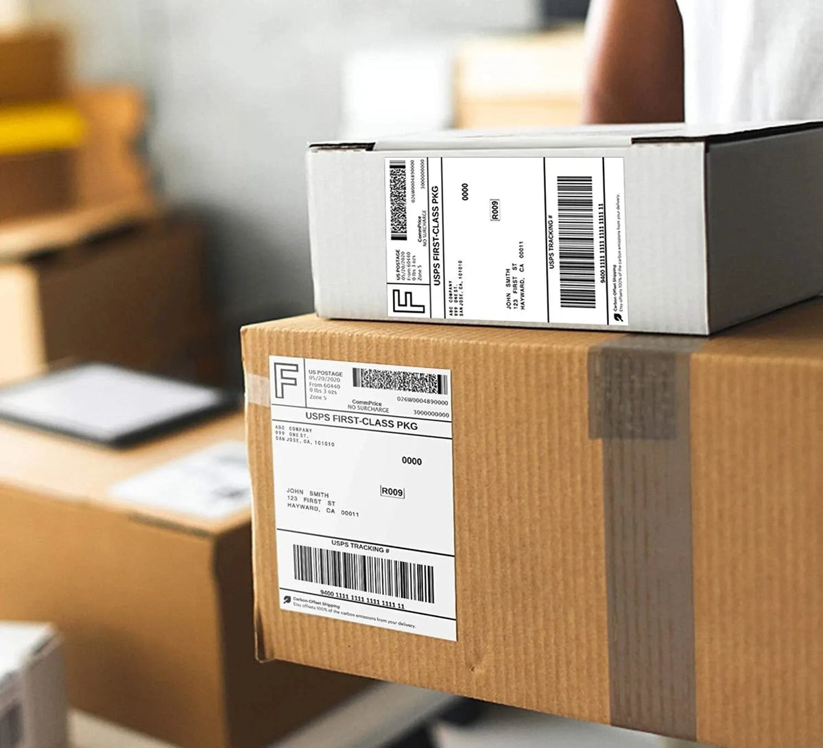 Close-up thermal shipping labels on stacked brown cardboard boxes, barcode stickers