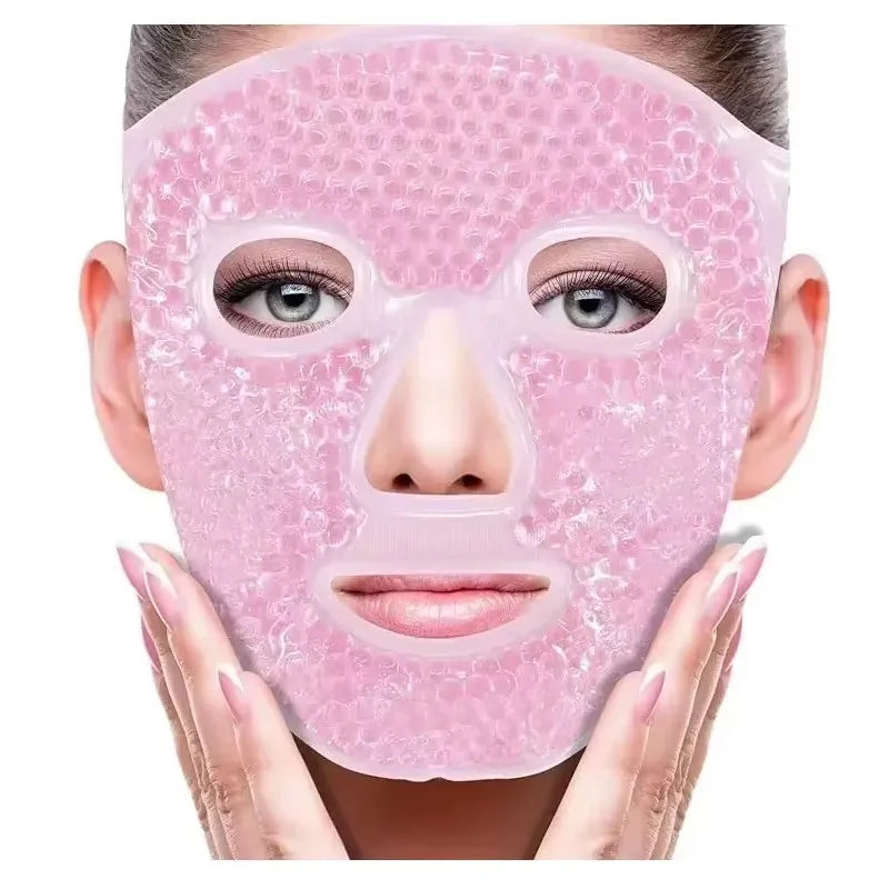A person wears a pink, gel-bead cooling face mask with cutouts for eyes, nose, and mouth against a white background.