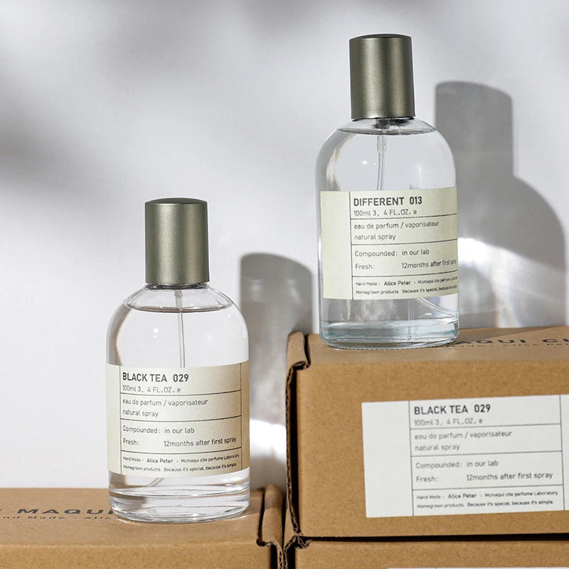Alice Peter unisex 100ml EDP bottles: Black Tea & Different 013, minimal round glass design with grey metal caps.