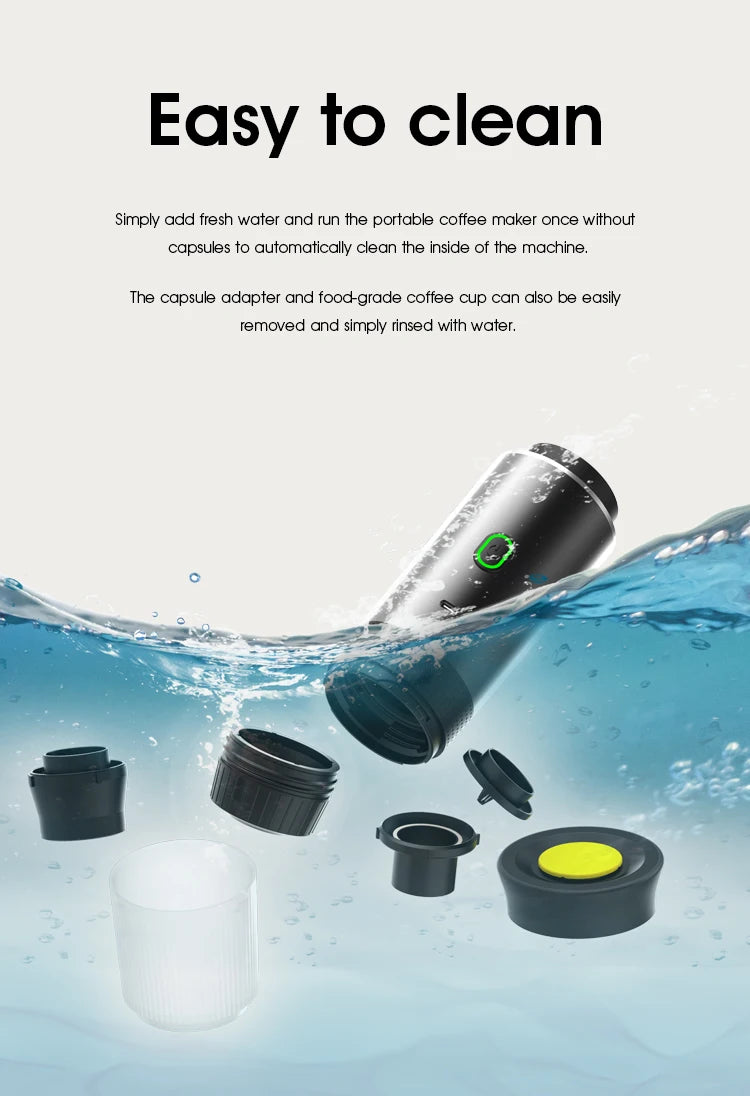 Black portable capsule coffee maker with detachable parts and cup, submerged in water to show easy cleaning features.