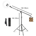 Black ring light on boom stand with counterweight bag, remote, and power cord. Adjustable height and extension arm.