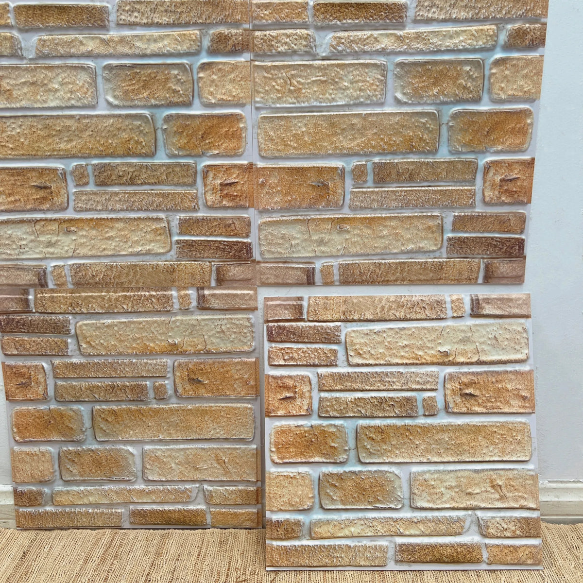 Peel-and-stick backsplash tile sheet with gold-beige brick pattern and speckled finish