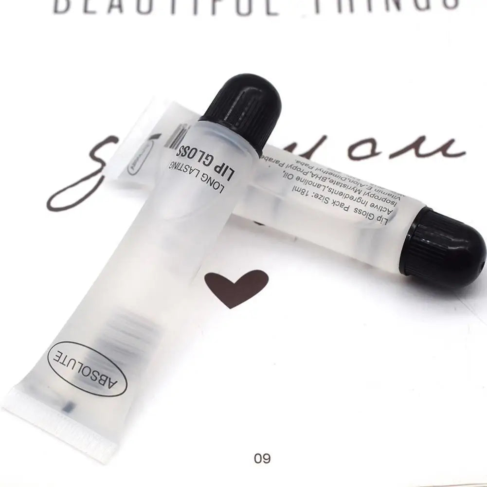 Two clear, long-lasting Absolute moisturizing lip gloss tubes with black caps on a white surface.