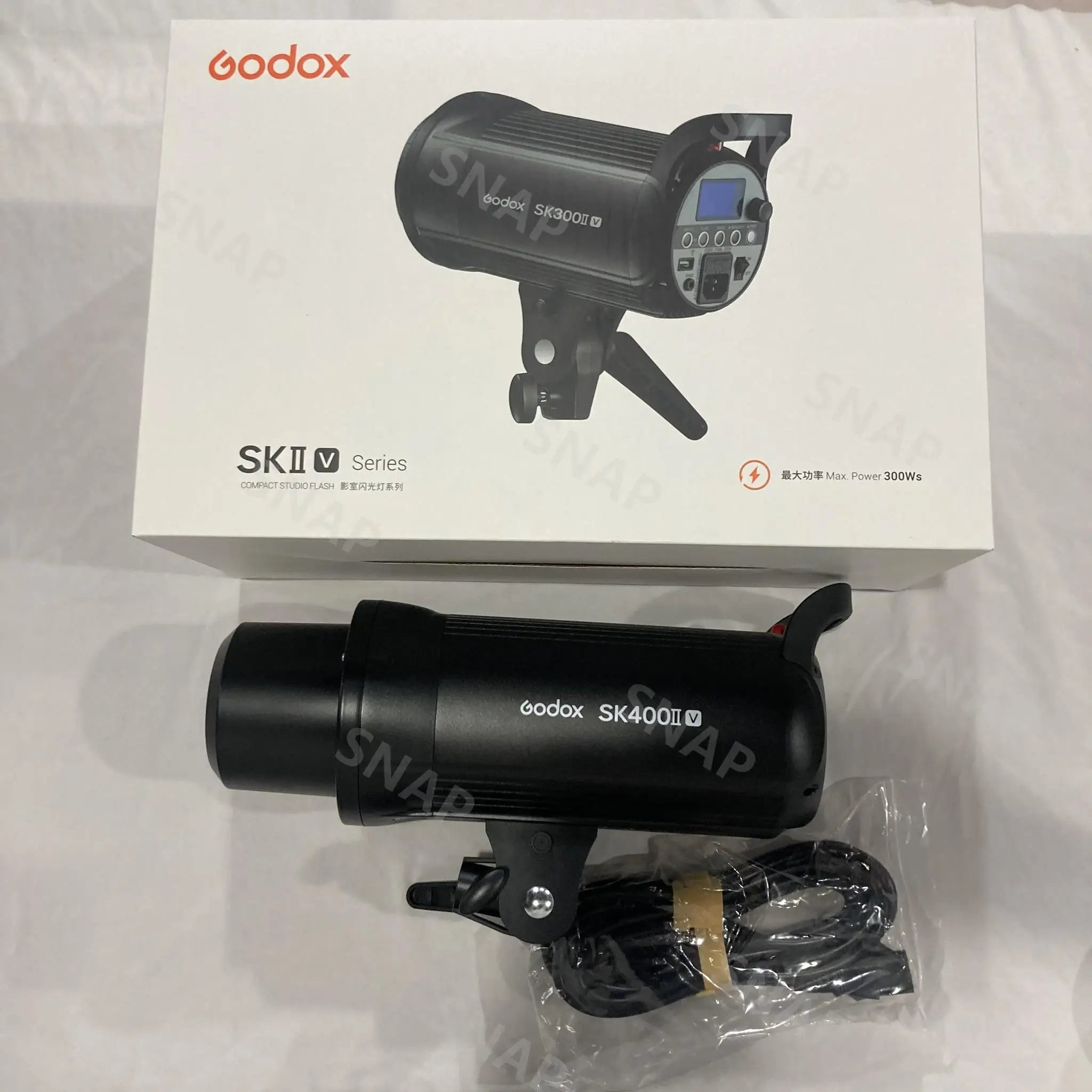 Black SK400II-V studio flash unit with power cable, shown with its original retail packaging box.