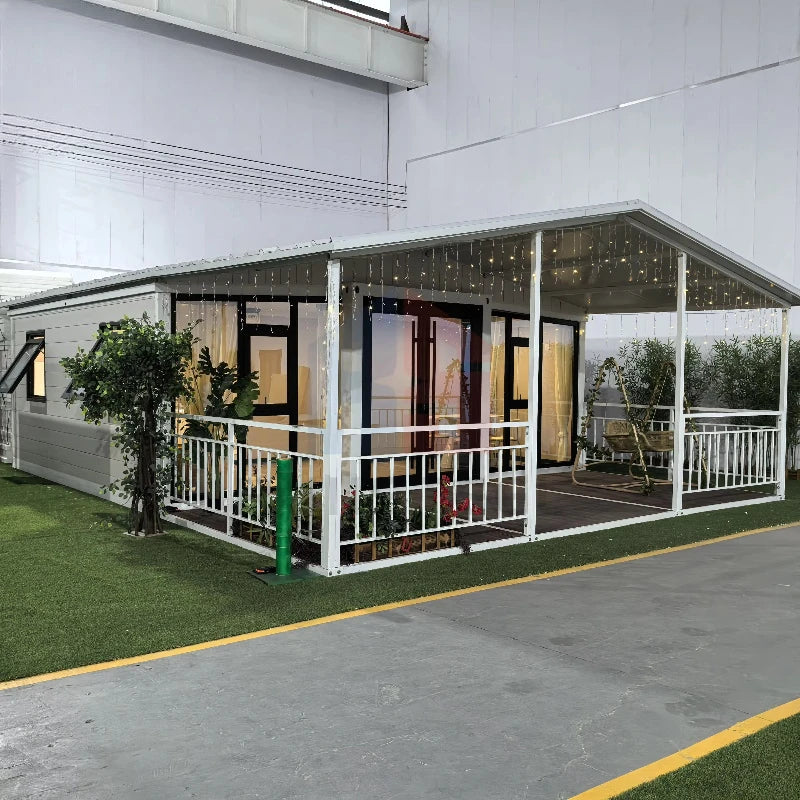 Steel prefab container house with open veranda, white railings, and glass walls