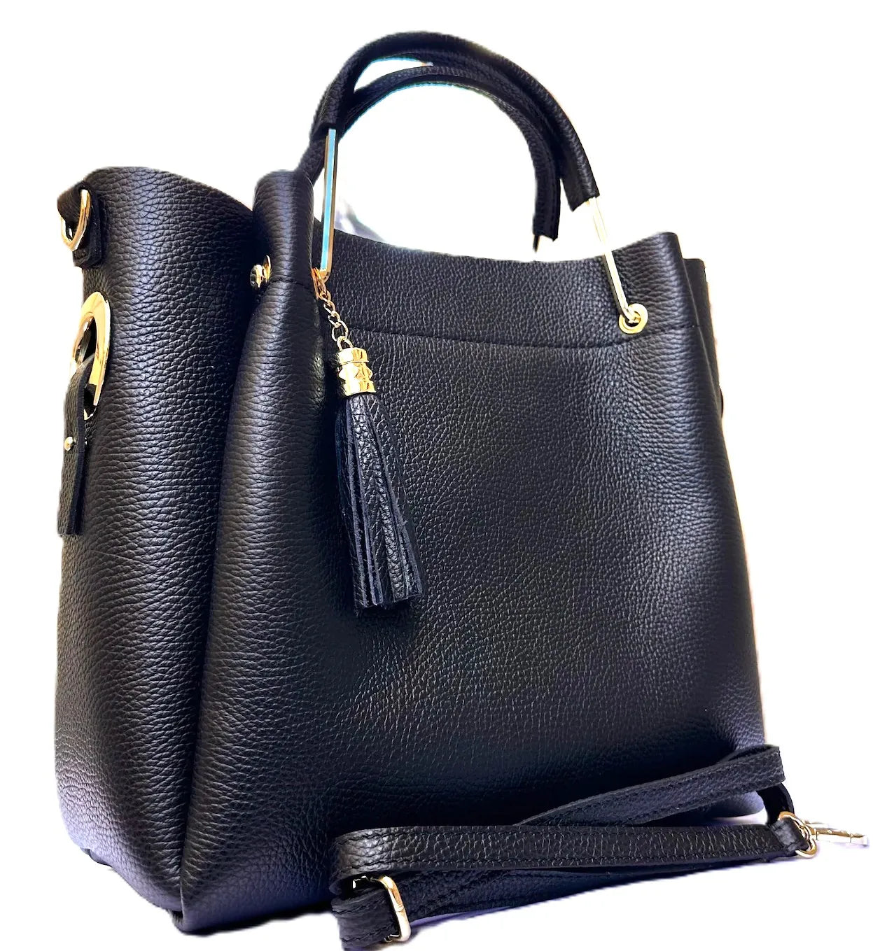 Royaa black handmade genuine leather tote bag with gold accents, tassel charm, zipper closure, and shoulder strap.