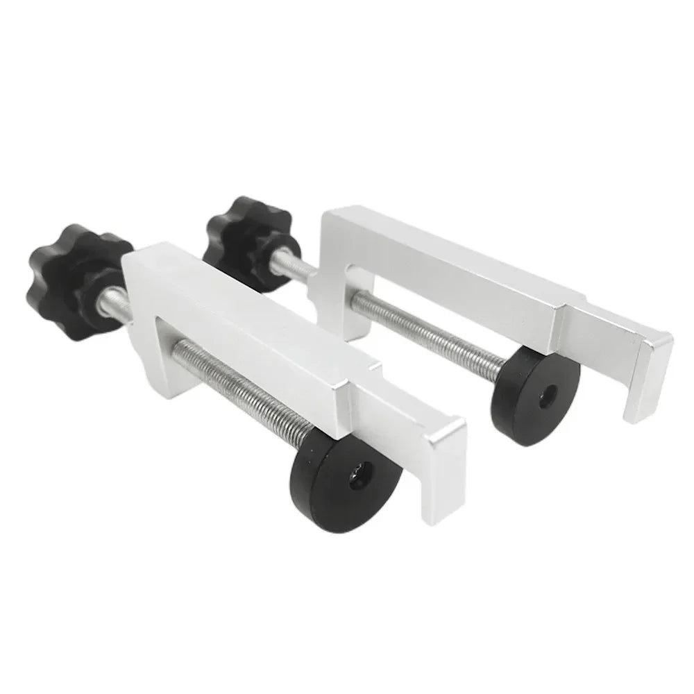 Engraving guide rail clamp bracket with white metal arms and black adjustment knobs