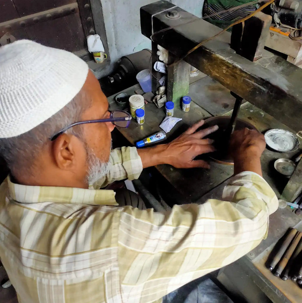 Jewelry workshop worker using polishing tools at a workbench