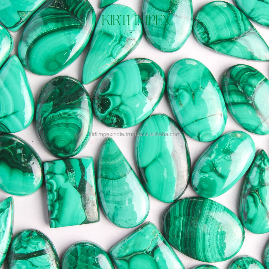Close view of green malachite oval cabochons with layered bands and polished shine