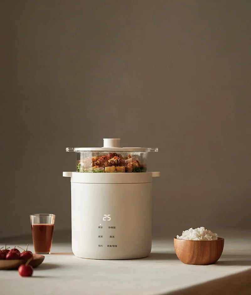 White electric rice cooker on countertop with lid open and food steaming