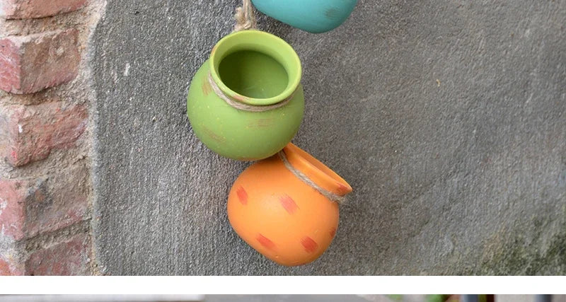 Ceramic hanging flowerpots: lime-green and orange pots with rope for plants