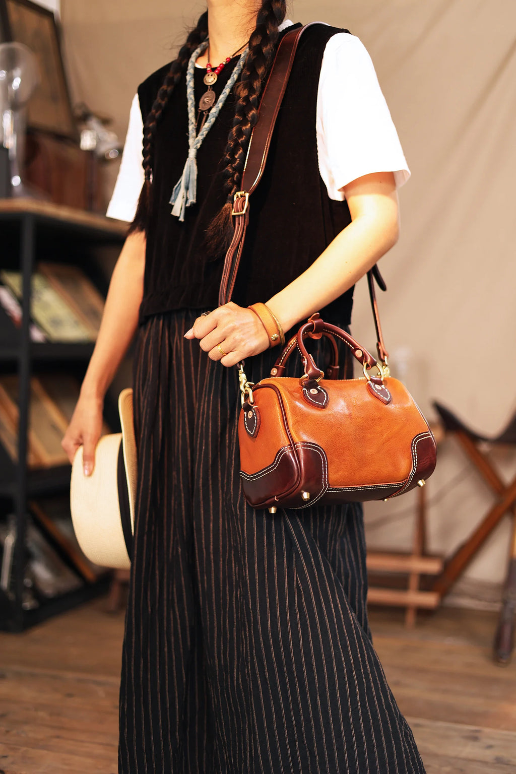 Vintage designer small brown leather shoulder bag, handmade cowhide barrel handbag with dark contrast trim detailing.