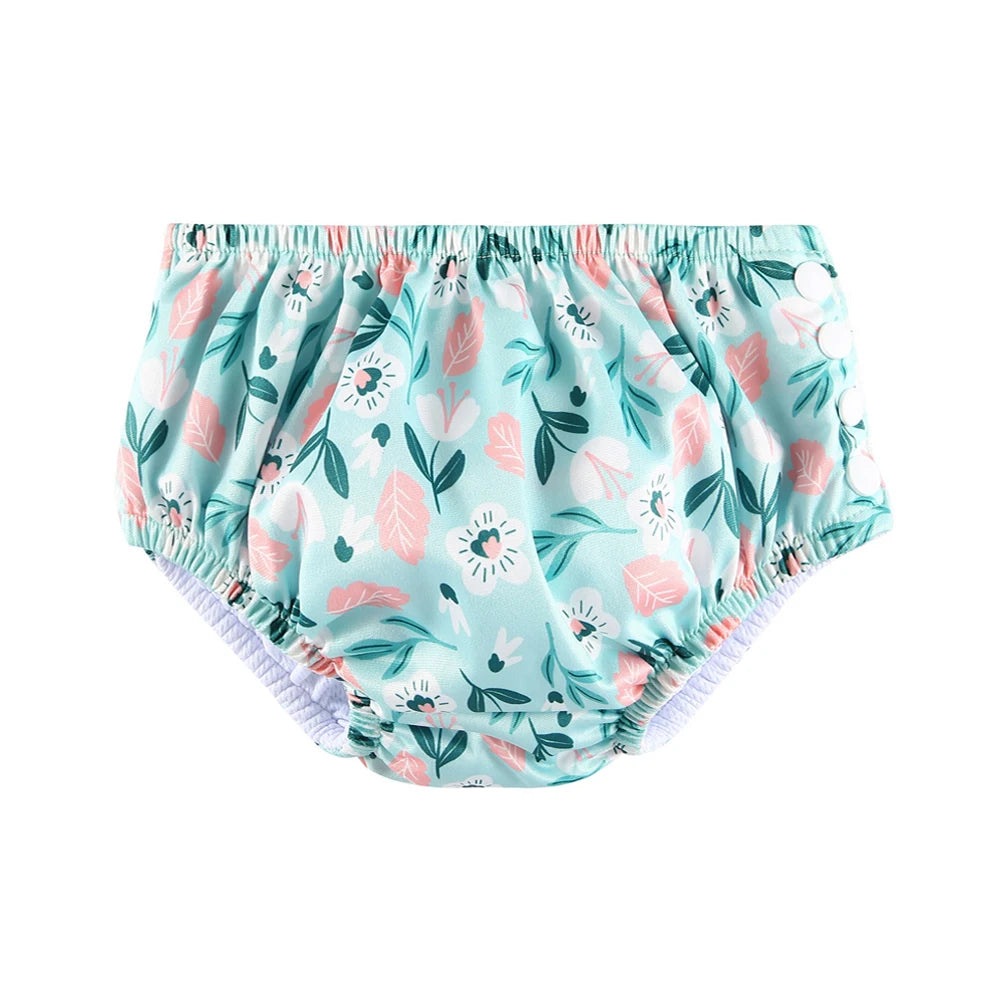 Reusable baby swim diaper in teal with a floral print and snap-side closure for secure fit.