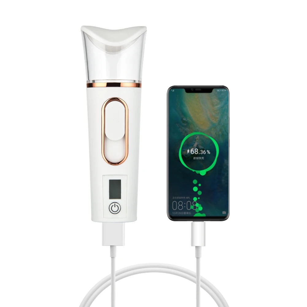 Portable white nano facial sprayer and humidifier with gold trim, shown charging alongside a smartphone.