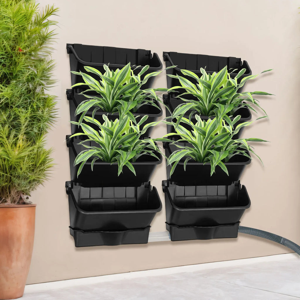 Vertical wall-mounted planter set with six black pockets holding green leafy plants