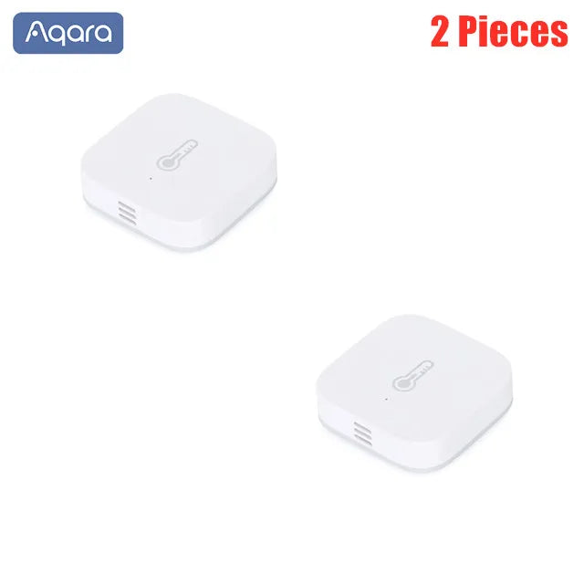Two square, white Aqara plastic temperature and humidity sensors with a thermometer icon on the top surface.