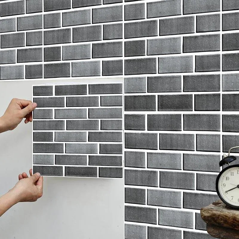 Peel-and-stick backsplash tile sheet with gray brick pattern, held by two hands