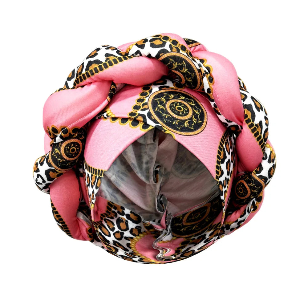 Tidesmit pink braided turban hat with gold chain, leopard, and medallion print in soft, stretchy jersey fabric.