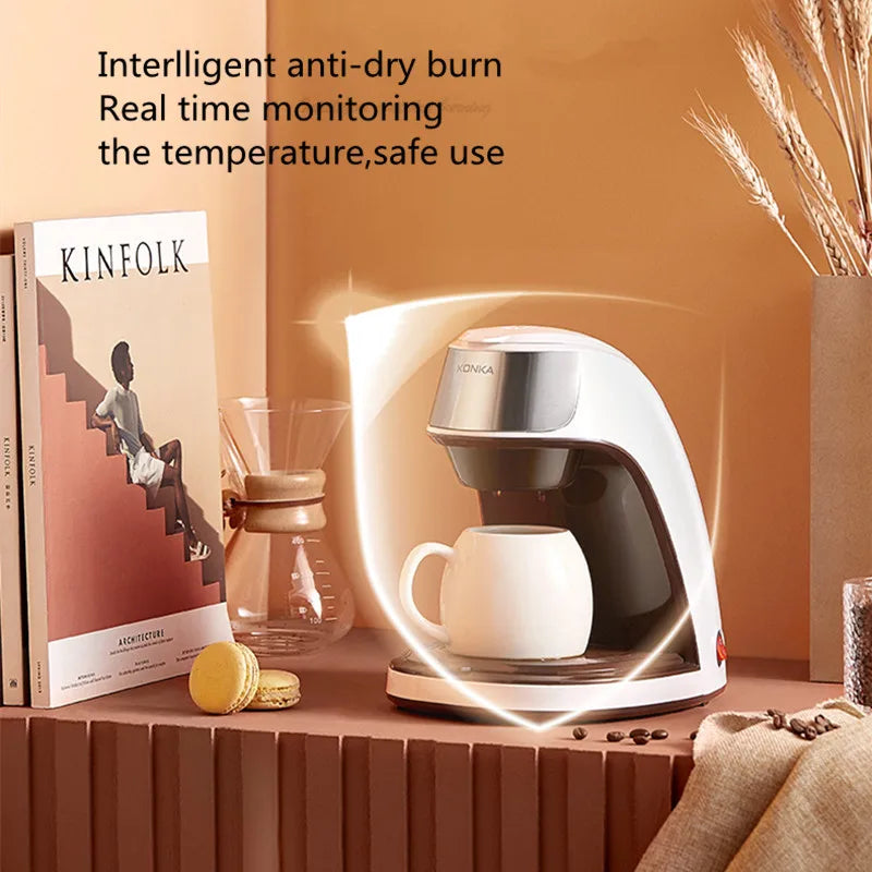 White and metallic Konka single-serve coffee maker with intelligent anti-dry burn safety feature on a kitchen counter.
