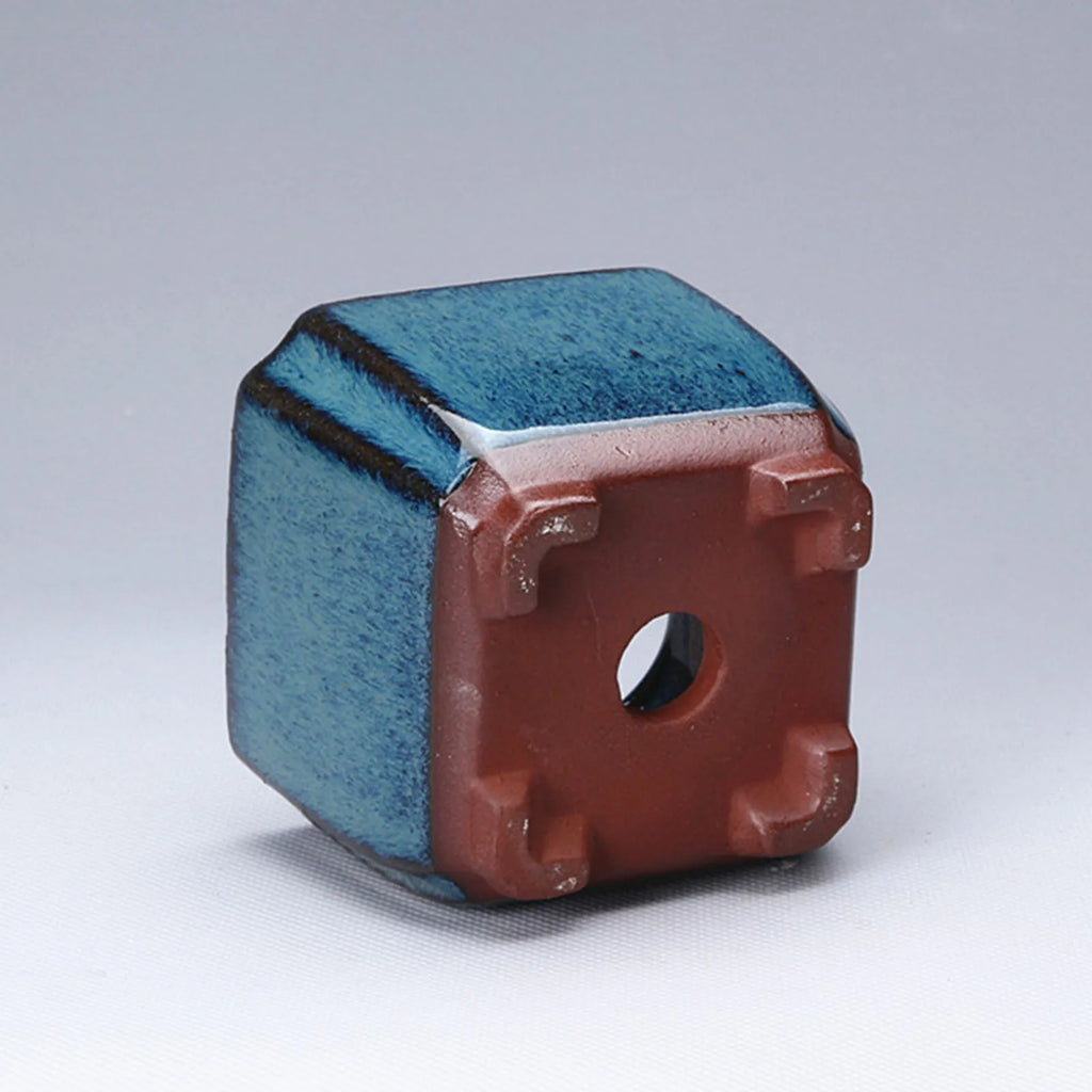 Blue glazed ceramic pot angled view showing terracotta side vents and hole