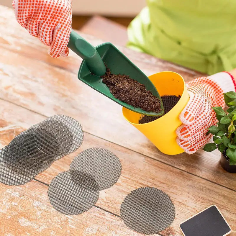 Set of round gray mesh drainage pads with grid holes on wooden surface