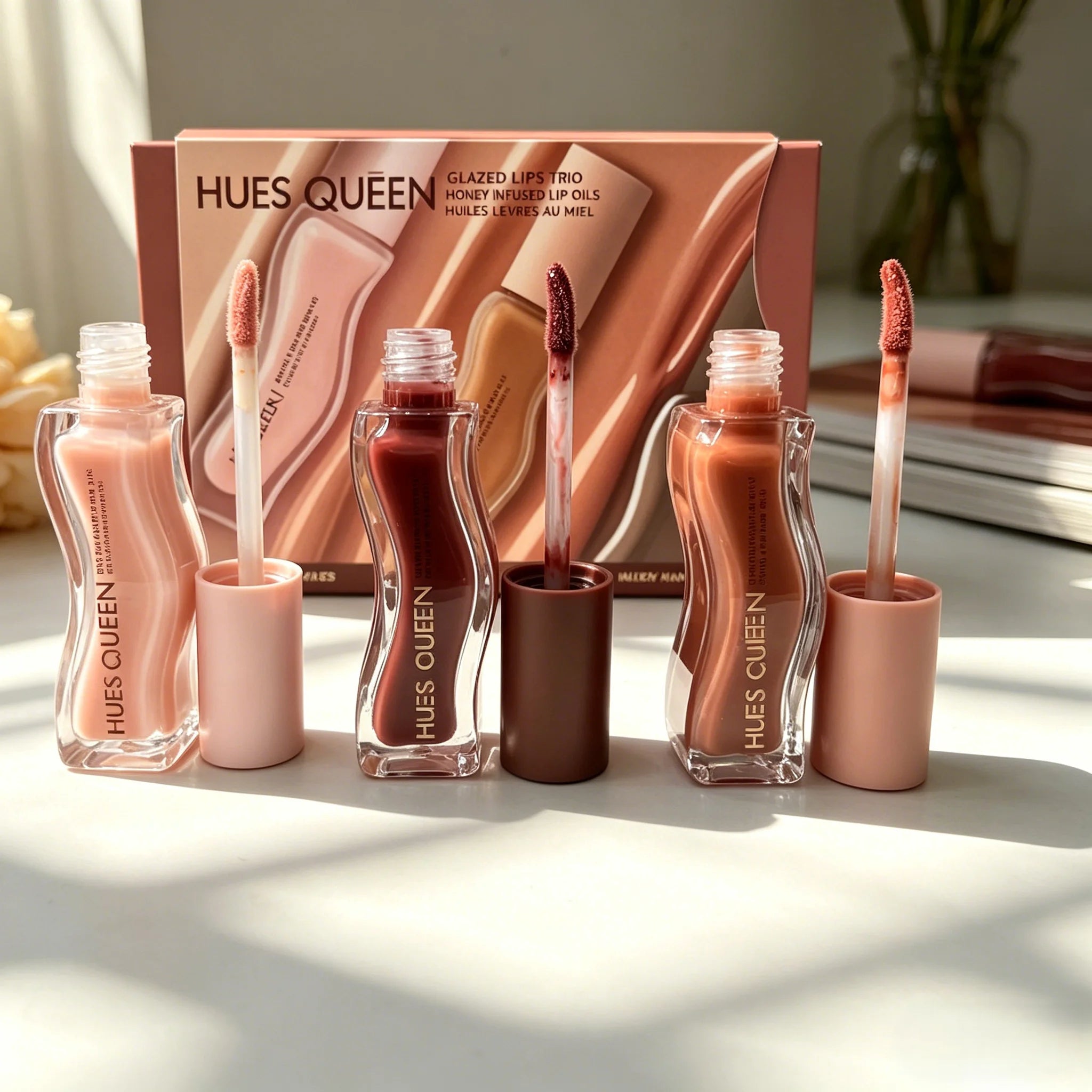 Hues Queen 3-piece hydrating lip gloss set in nude, berry, and brown shades with shiny, moisturizing textures.
