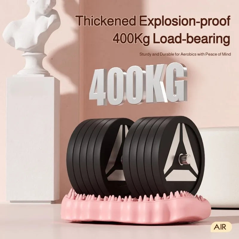 A pink, inflatable, textured acupoint foot massage mat topped with two black circular weight plates.