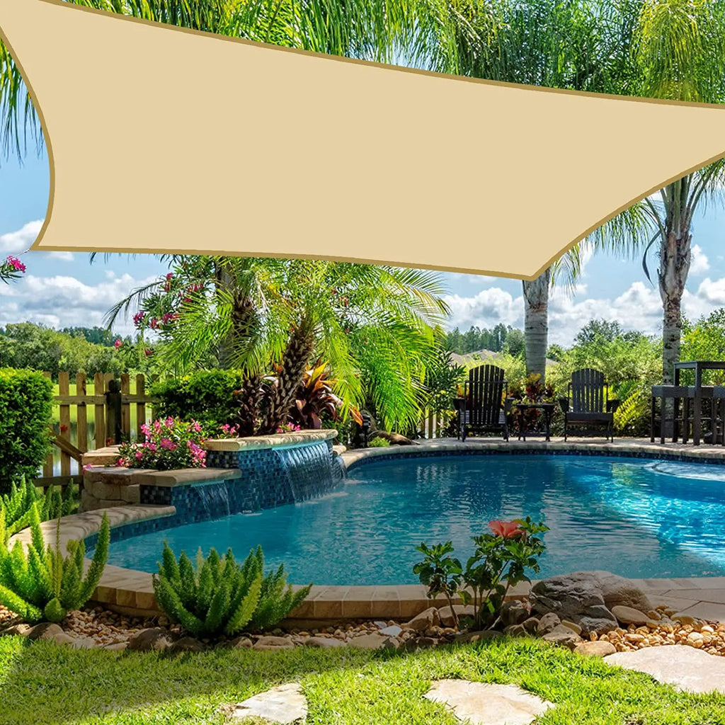 Beige waterproof rectangle sun shade sail canopy over a poolside garden area
