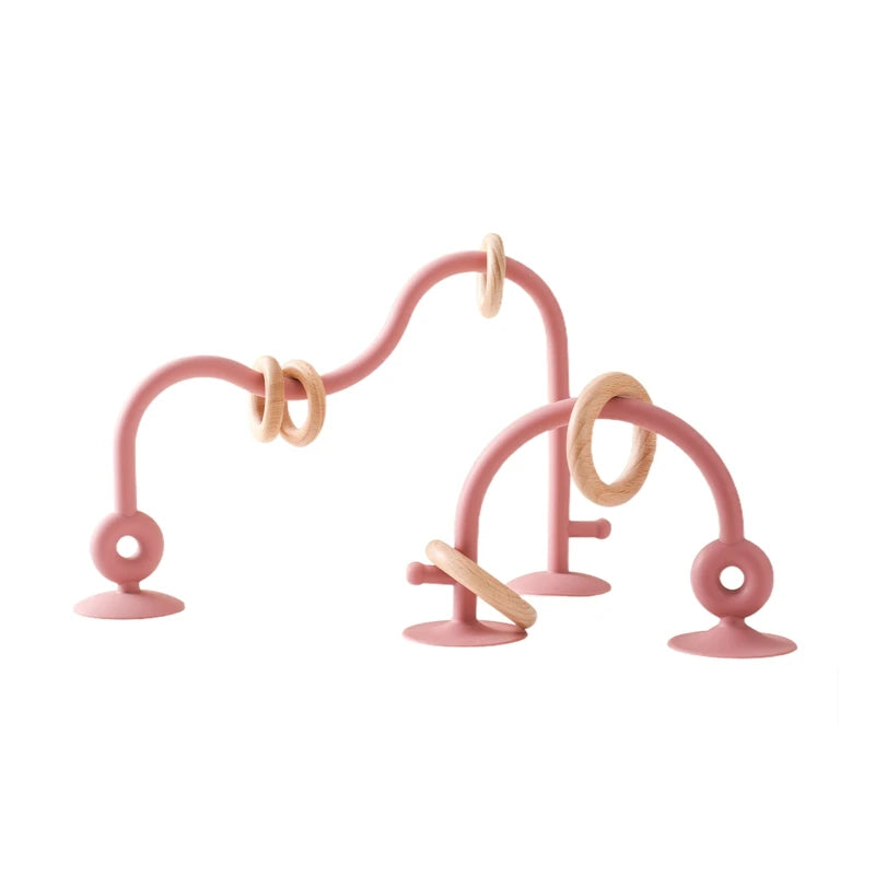 Pink silicone and natural wood baby teething toy arches for soothing infant teething relief.