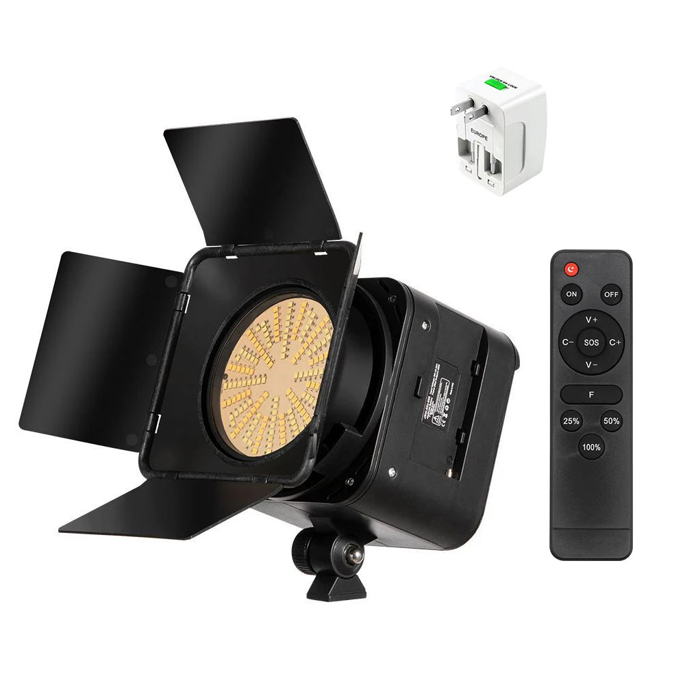 Black LED video light with barn doors, remote control, and a travel power adapter for studio and photography lighting.