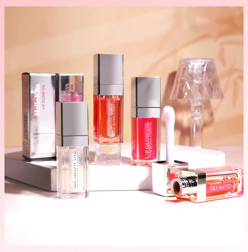 Set of moisturizing crystal jelly lip glow oils in various tinted shades with glossy, plumping texture and applicator.