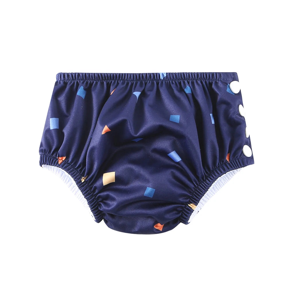 Reusable navy blue baby swim diaper with geometric print and side snap buttons for adjustable fit.