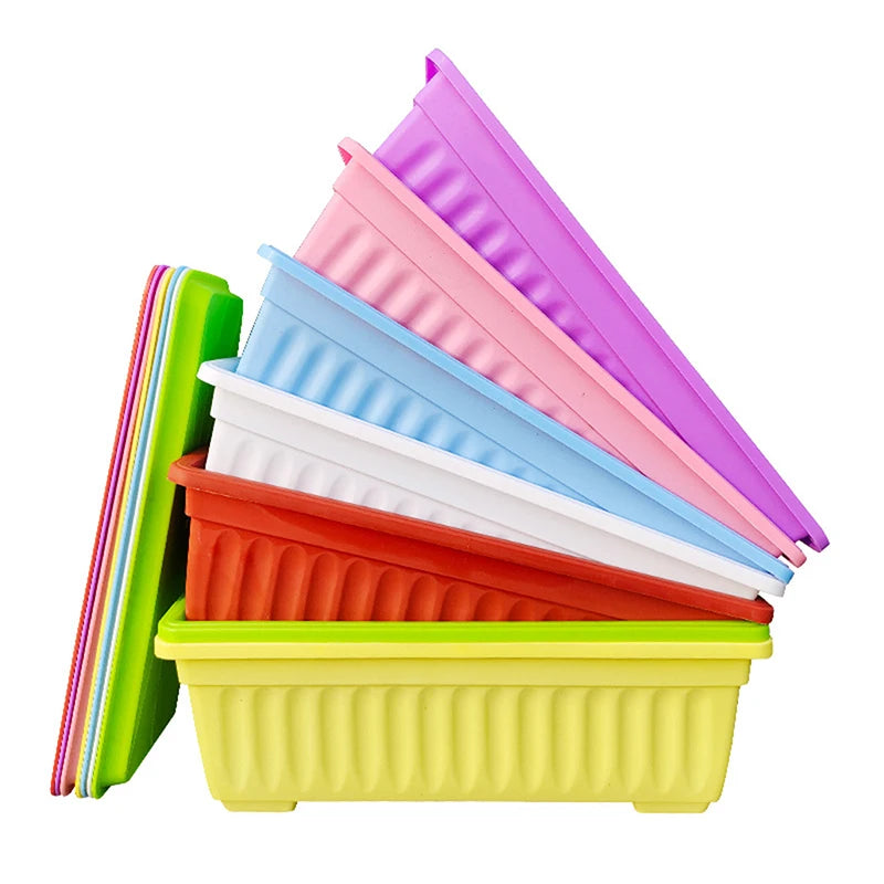 Stack of rectangular plastic planters in purple, pink, blue, orange, and green
