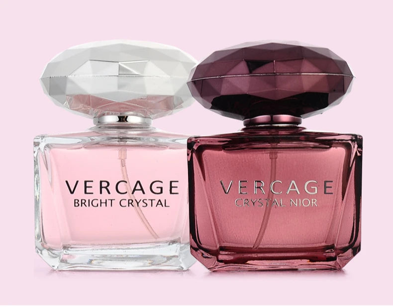 Two Vercage 50ml luxury women’s perfumes with faceted diamond-style caps in clear pink and deep purple glass bottles.