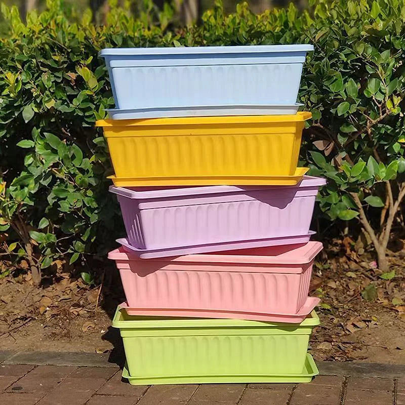 Rectangular plastic planters set in white, yellow, pink, and green stacked outdoors