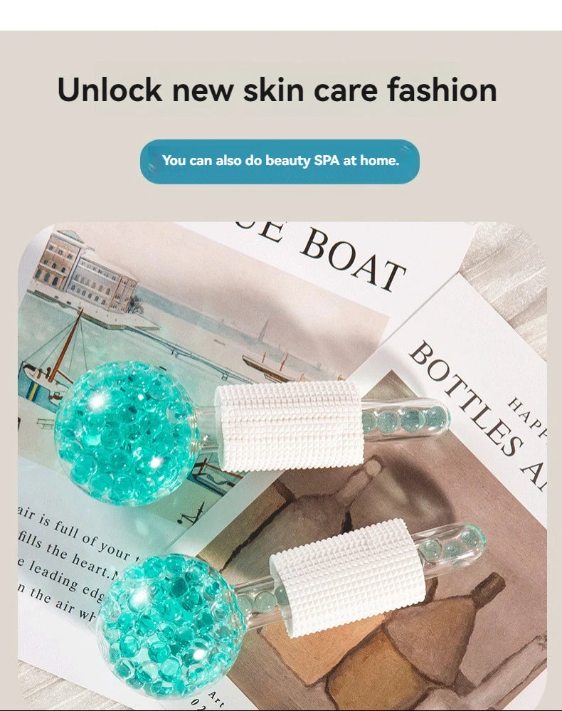 Two cooling facial globes with teal spherical heads filled with beads and textured white grips, resting on magazines.