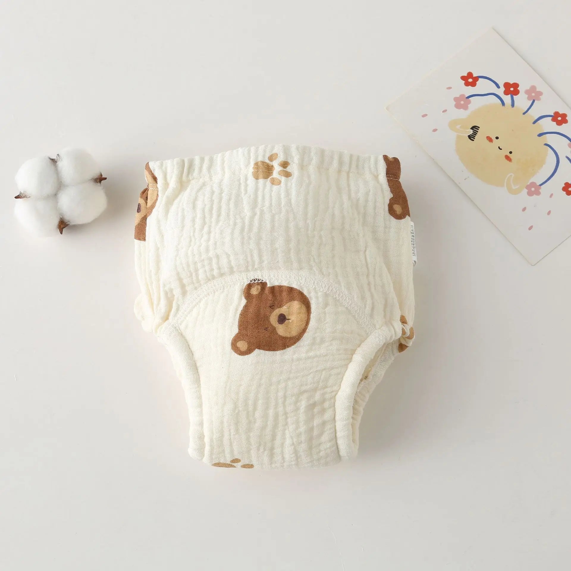 Soft muslin baby cloth diaper with cute bear print and paw accents, essential baby care for infants.