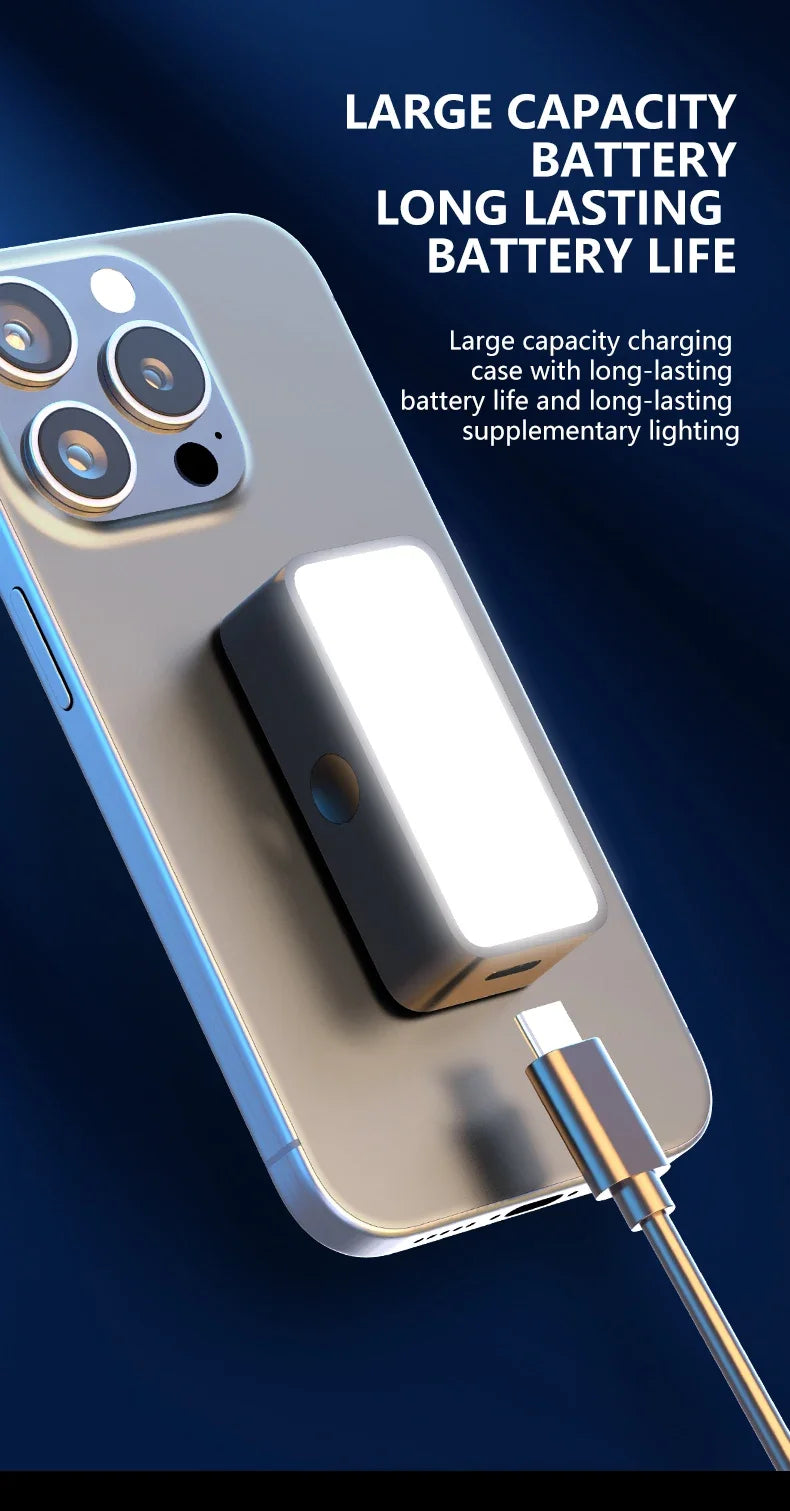 Rectangular grey LED phone light attachment with a white panel, connected to a USB-C cable on a smartphone.