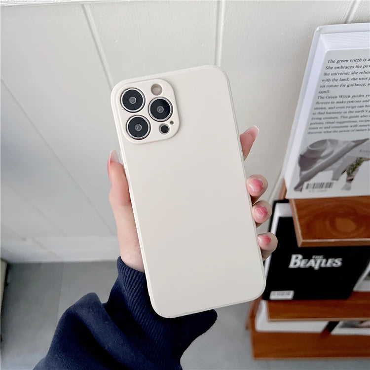 Cream-colored silicone iPhone case with a square camera cutout, held in a hand for protective mobile device coverage.