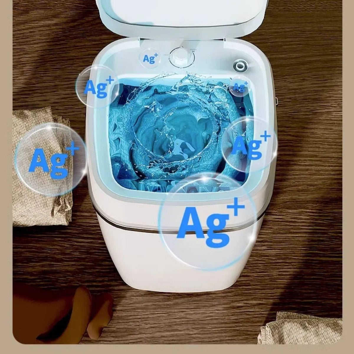 Mini washing machine with Ag+ silver ion sterilization washing clothes with swirling water inside a compact white tub.