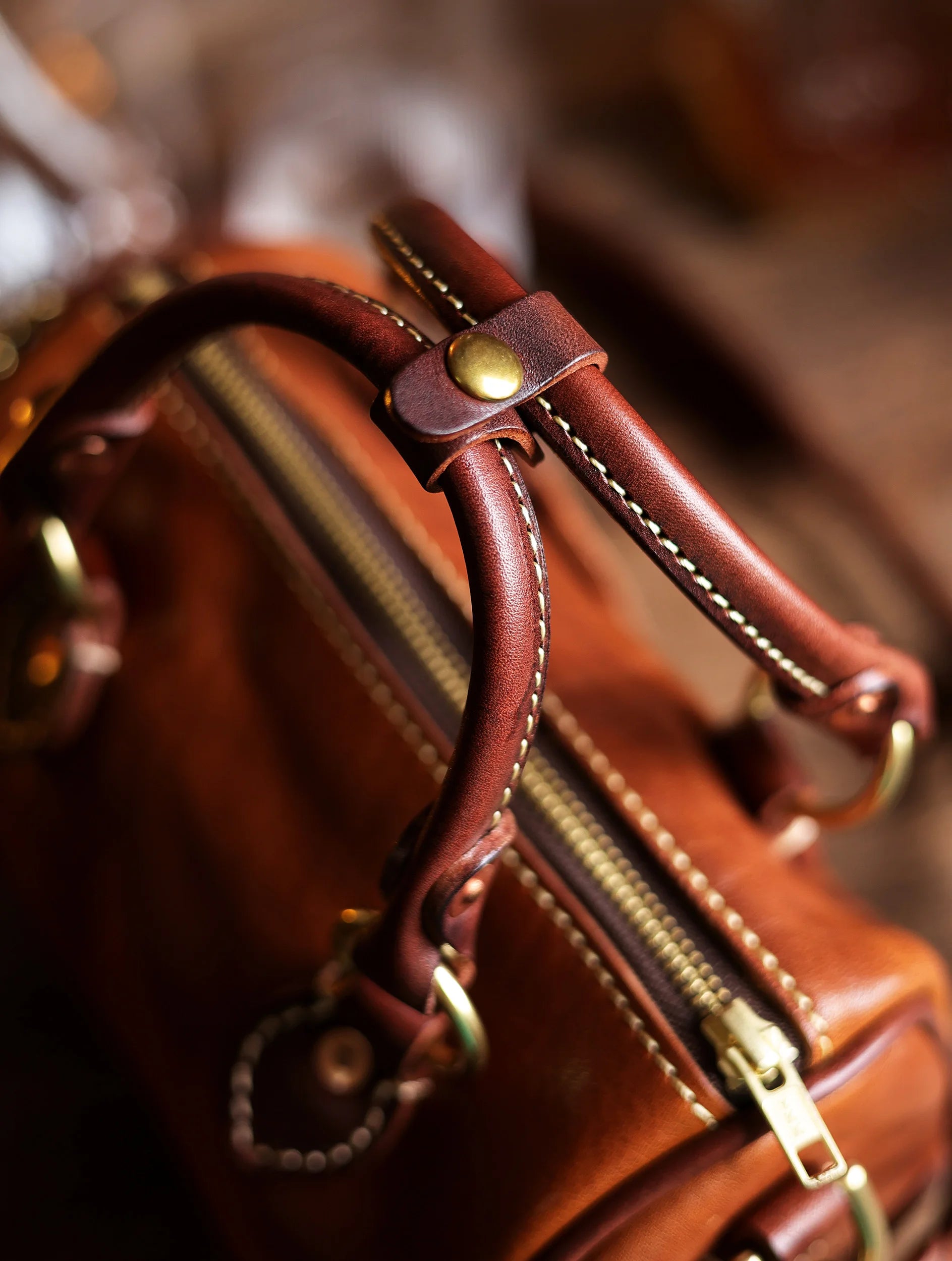 Vintage brown genuine cowhide leather handbag with stitched handles, brass hardware, and a secure top zipper.