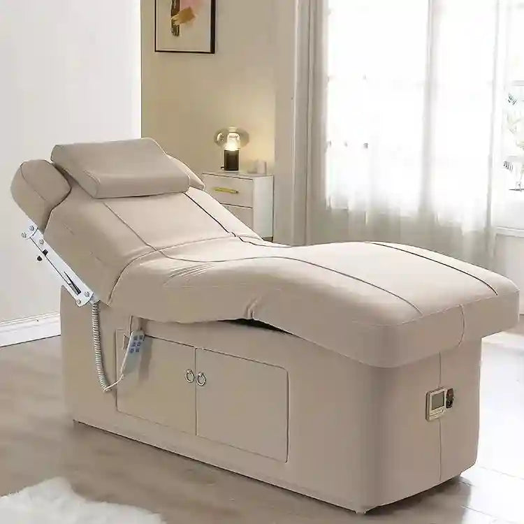 Beige electric spa treatment bed with adjustable backrest, padded headrest, and built-in storage cabinet base.