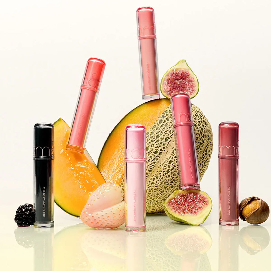 rom&nd Juicy Lasting Tint collection in various shades with fresh fruit for a glossy, hydrating Korean lip makeup look.
