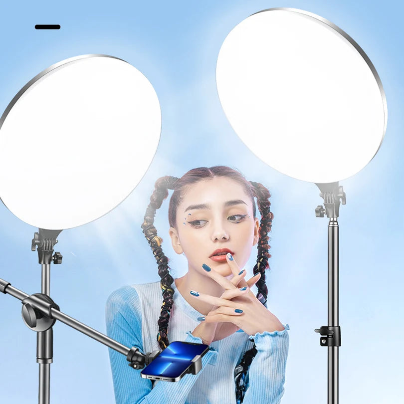 Two large, white, circular LED ring lights on adjustable metal stands with a phone mount for content creation.