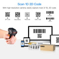 Wearable ring barcode scanner with black body and orange trigger, held on finger