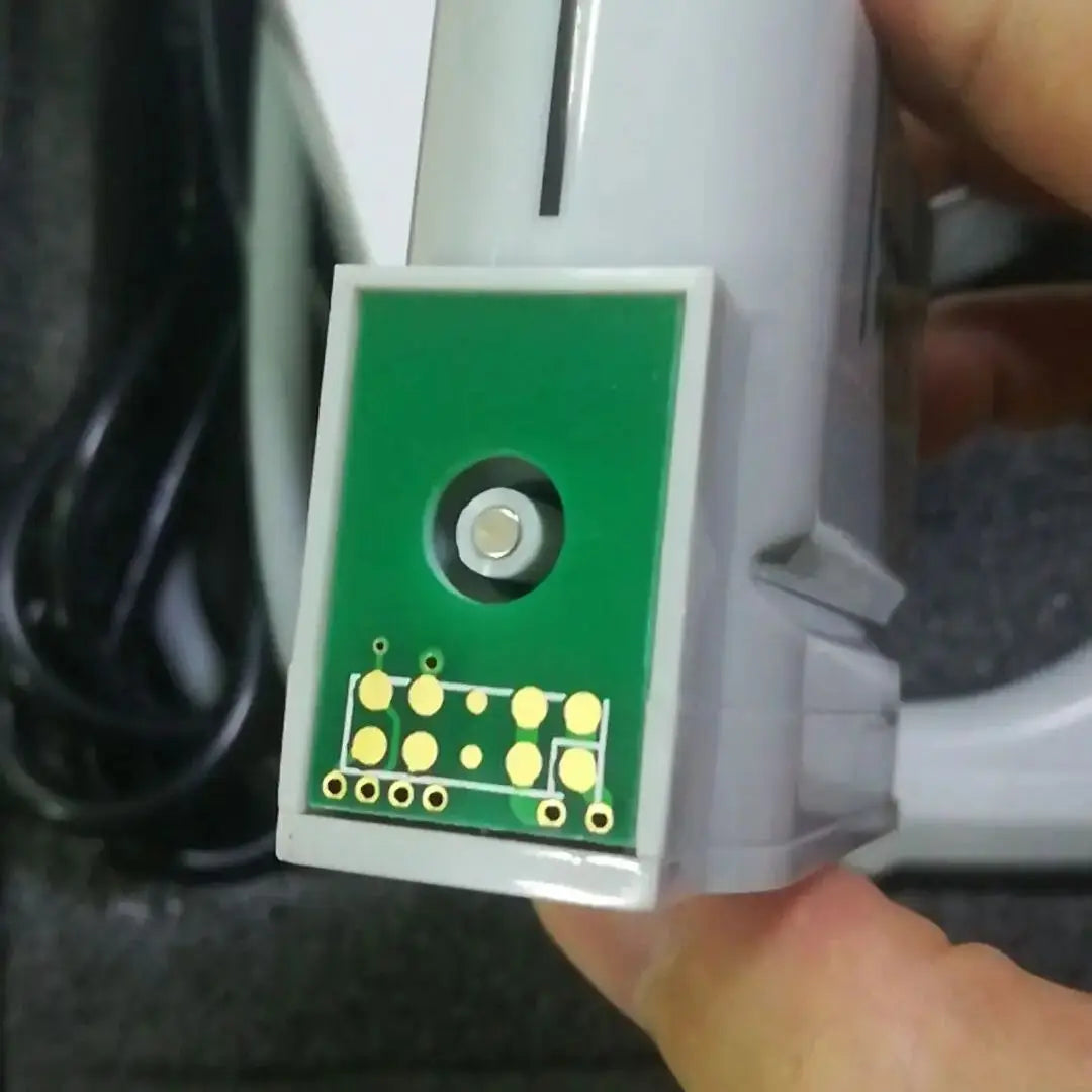 Gray plastic HIFU machine cartridge with a green circuit board base, gold contact points, and a central transducer.
