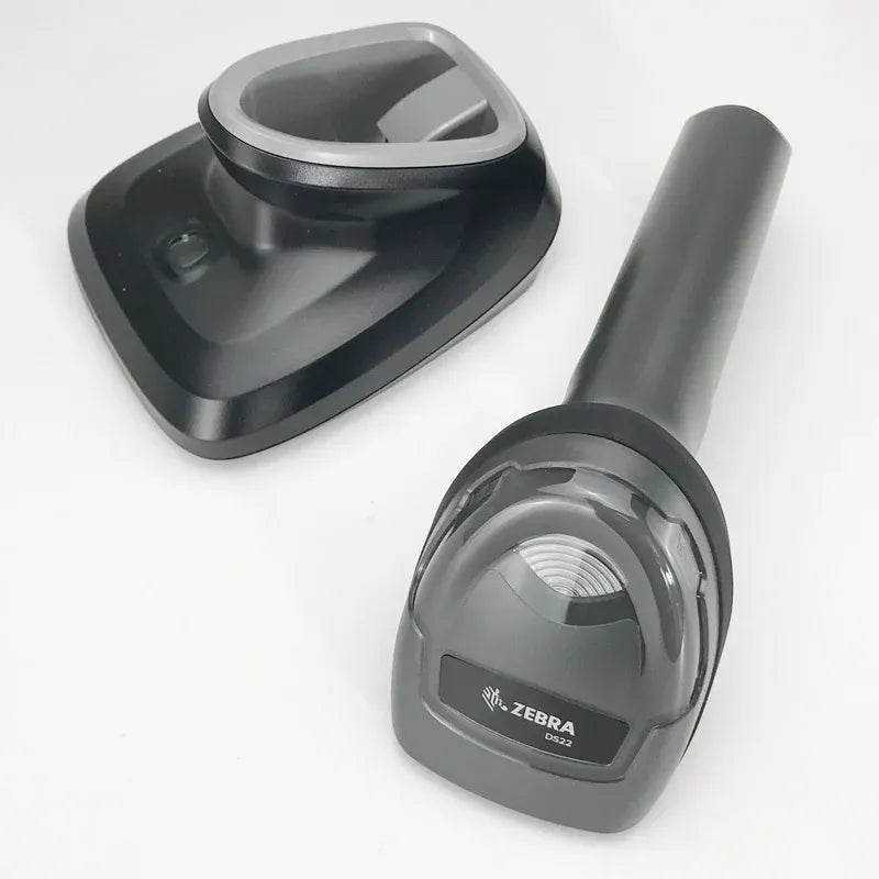 Dark gray handheld barcode scanner on dock base with green status light