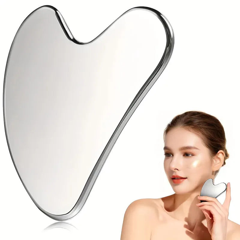 Smooth, heart-shaped silver stainless steel facial gua sha tool being used by a woman on her jawline.